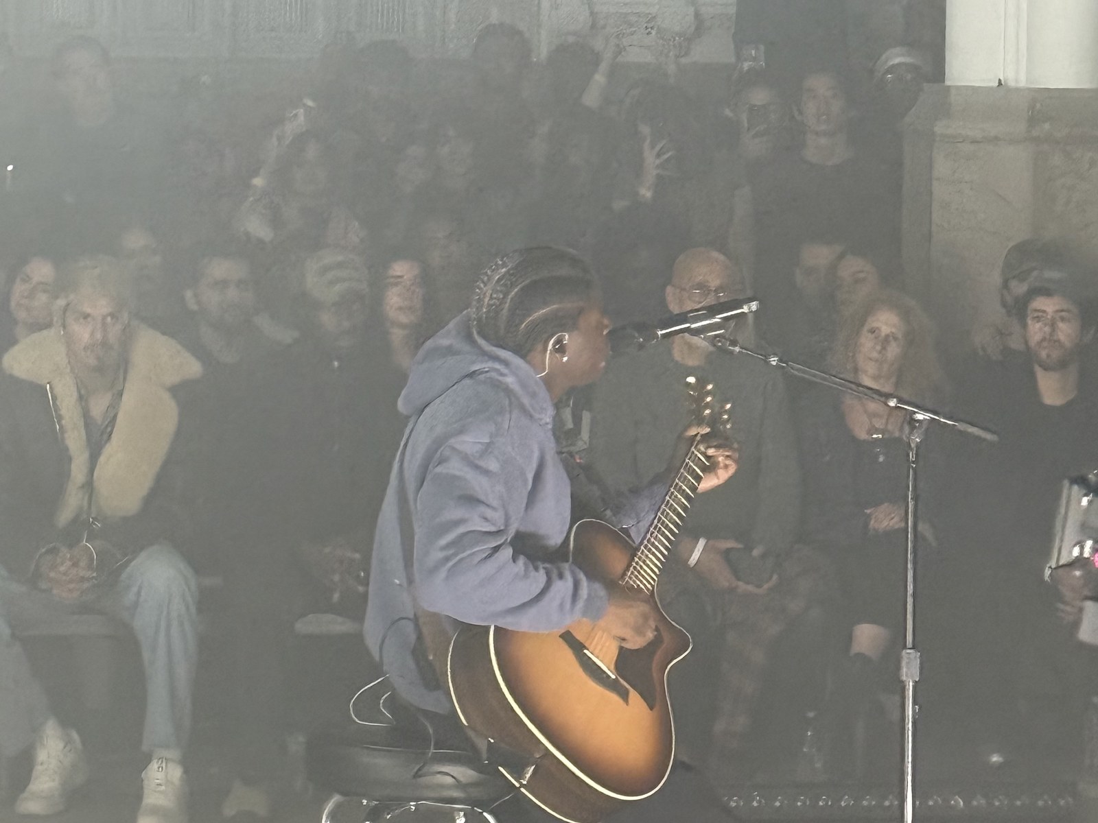 Daniel Caesar performing seated with guitar